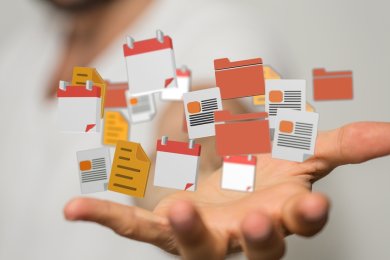 Symbolbild Datenverarbeitung Nahaufnahme einer offenen and. Darüber schweben Piktogramme von Formularen, Ordnern und Kalenderblättern.