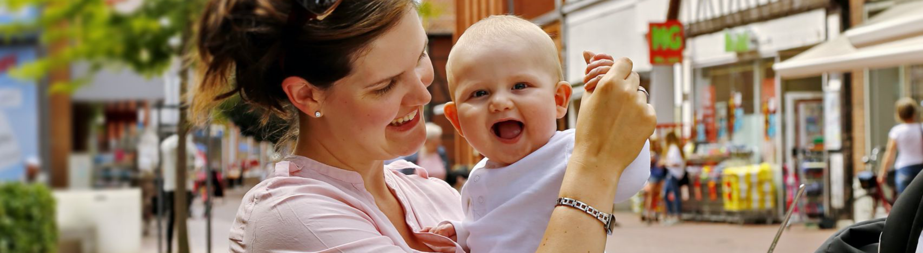 Mutter Mit Kind Mutter hat kleines Baby auf dem Arm, das lacht.