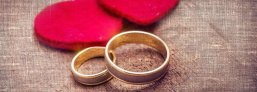 Ansicht zwei Ringe mit zwei roten Filzherzen auf beigem Stoffhintergrund