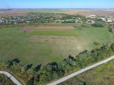 Symbolbild Neubaugebiet Blick auf ein Dorf aus der Vogelperspektive am Rand einer großen grünen Fläche