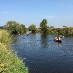 10 Jugendliche fahren mit Kanus auf einem Fluss