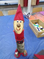 Gebastelter Wichtel aus einem Birkenstämmchen mit roter Pudelmütze