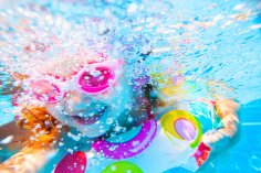little girls wimming in the pool in inflatable ring little girls wimming in the pool in inflatable ring