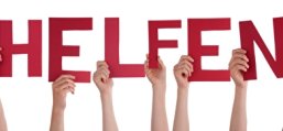 PantherMedia 28249797 Hände die ein ein Schild mit "Wir helfen" hochhalten