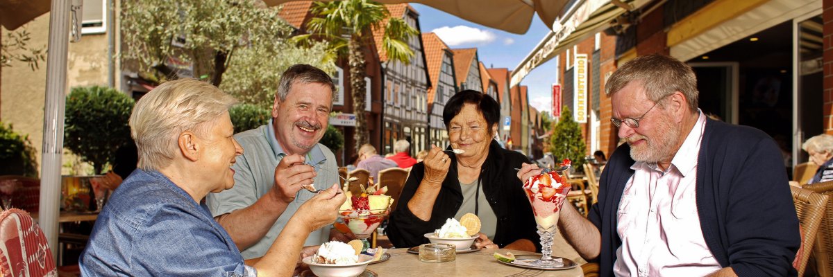 Symbolbild Senioren Vier ältere Menschen sitzen gemeinsam beim Eissessen in einem Eiscafe in der Innenstadt.
