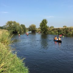 10 Jugendliche fahren mit Kanus auf einem Fluss