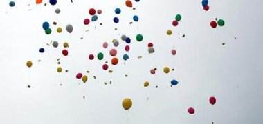 Zahlreiche bunte, in den Himmel aufsteigende Luftballons 