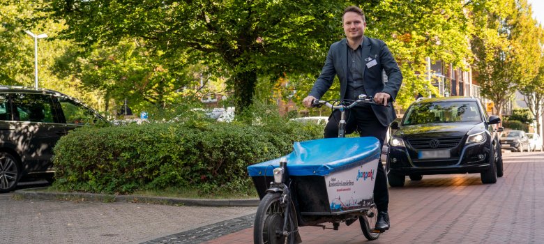 Bürgermeister Dominic Herbst fährt auf dem Lastenrad Hannah durch die Innenstadt.