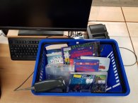 blauer Korb mit Büchern und Medien, Barcodescanner, Ausleihe in der Stadtbibliothek