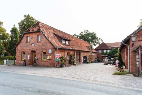 Biermanns Hof Eilvese Blick auf eine Hofstelle mit Einzelhandel, alte Fachwerkhäuser stehen in U-Form in der Mitte befindet sich ein gepflasterter Hof mit Sitzgelegenheiten