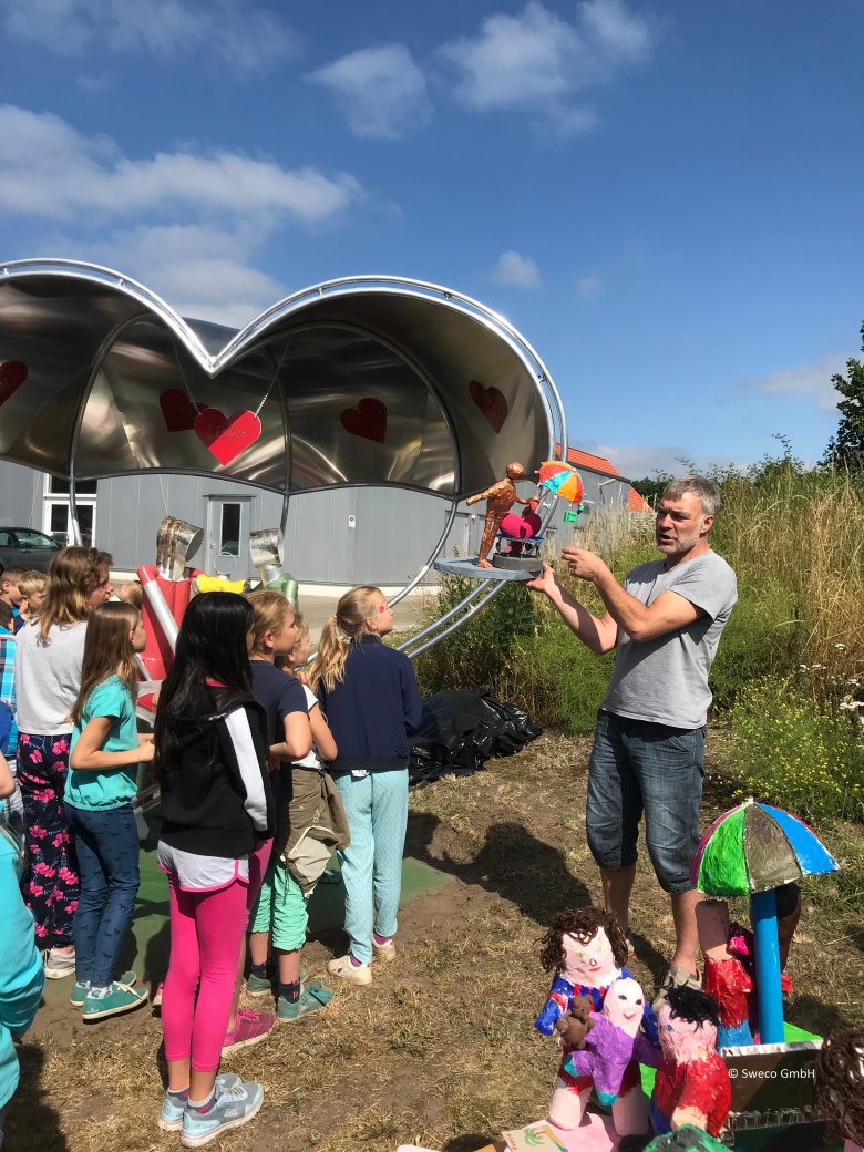 Künstler zeigt Kindern sein Kunstprojekt