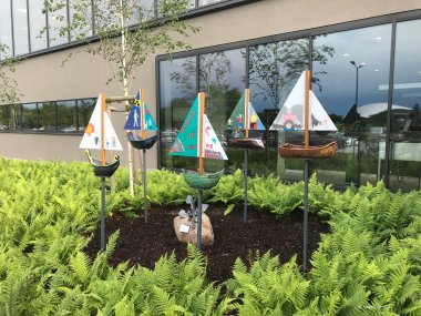 In der Erde stecken Stiele mit selbstgemachten Schiffen