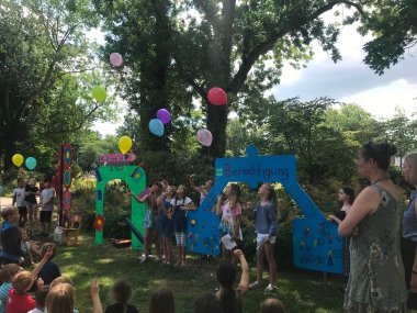 Kinder lassen im Freien Luftballons steigen