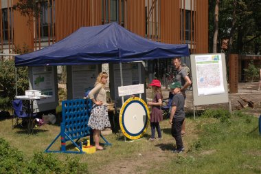 Auf dem Bild sind zwei Erwachsene und ein Kind zu sehen, die sich den Stand für Leader Meer & Moor anschauen