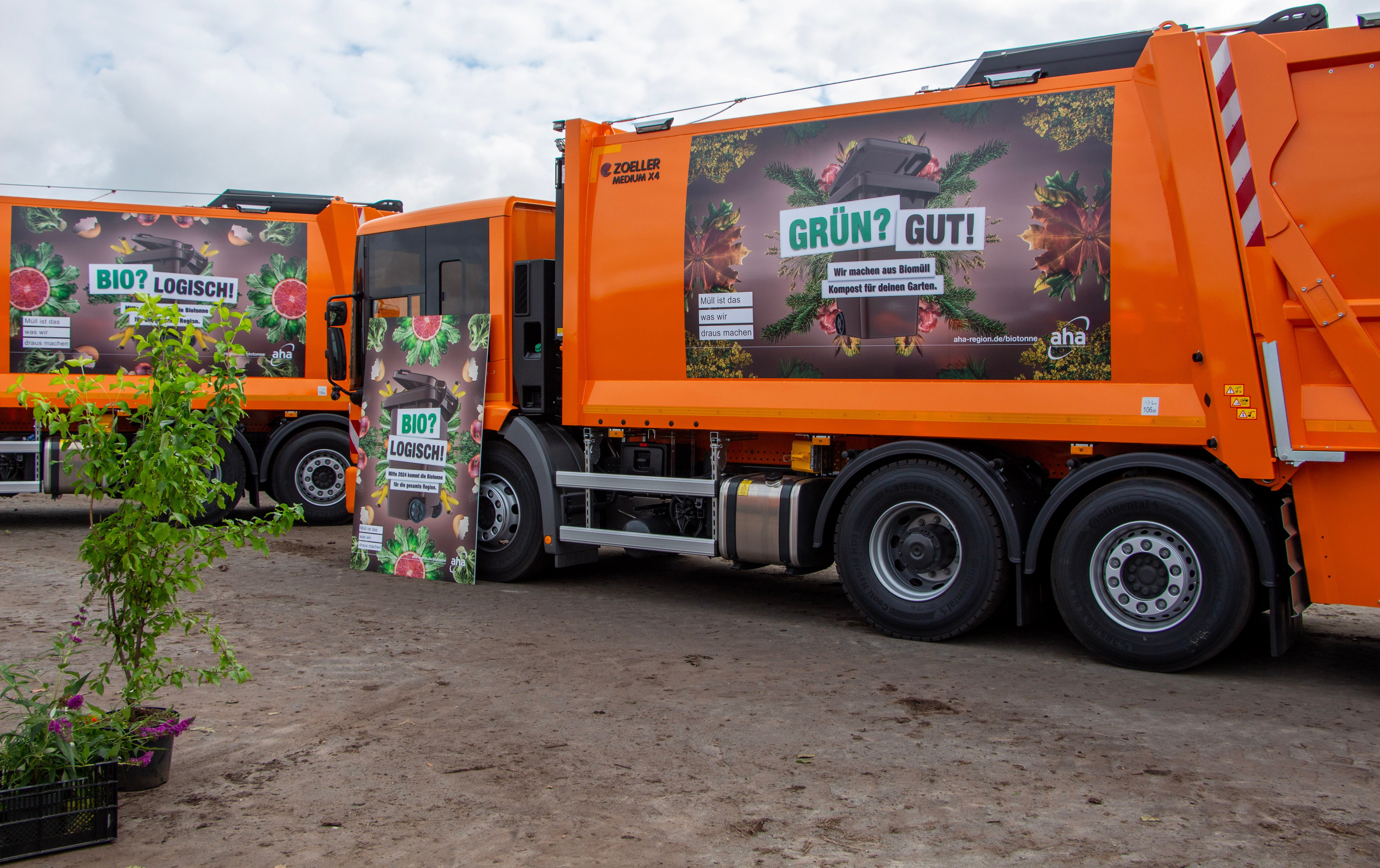 Pressefoto Einführung Biotonne Umland Aufnahme eines orangenen Müllwagens, der mit dem Kampangenmotiv zur Einführung der Biotonne im Umland bedruckt ist.