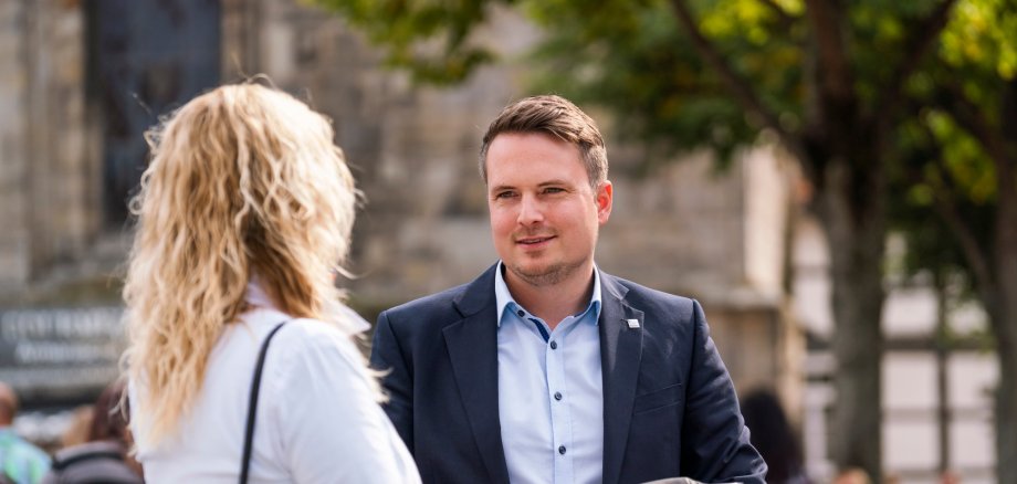 Bürgermeister Dominic Herbst (rechts) im Gespräch mit einer Frau (links)