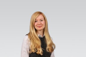 Portraitaufnahme einer Frau mit langen blonden Haaren. Sie blickt in die Kamera, 