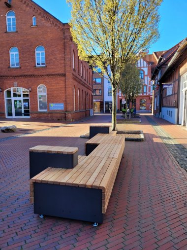 Pressefoto Sitzmöbel Draufgesetzt Am kleinen Wall eine längliche Sitzbank mit hözener Oberfläche und verschiedenen Sitzebenen steht in der Straße Am kleinen Wall.