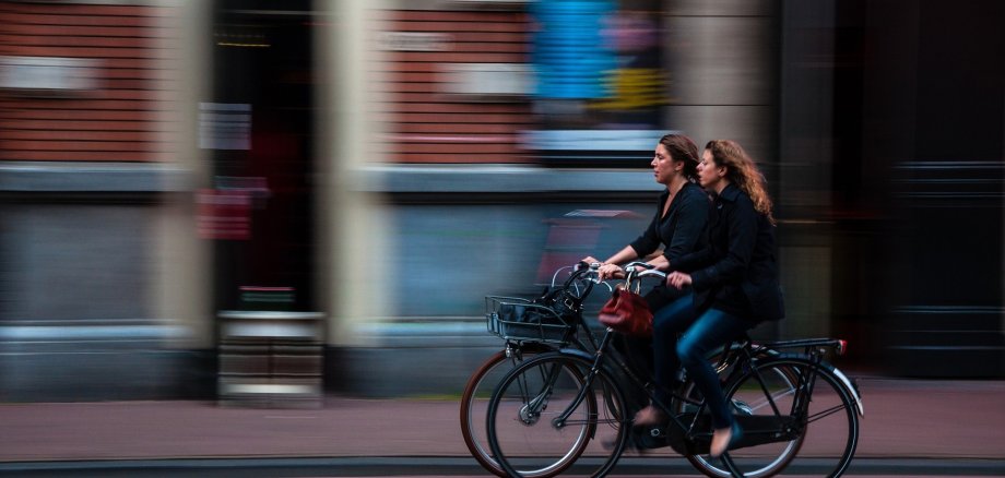Symbolbild Radverkehr Zwei Frauen fahren auf einem Radweg mit dem Fahrrad.