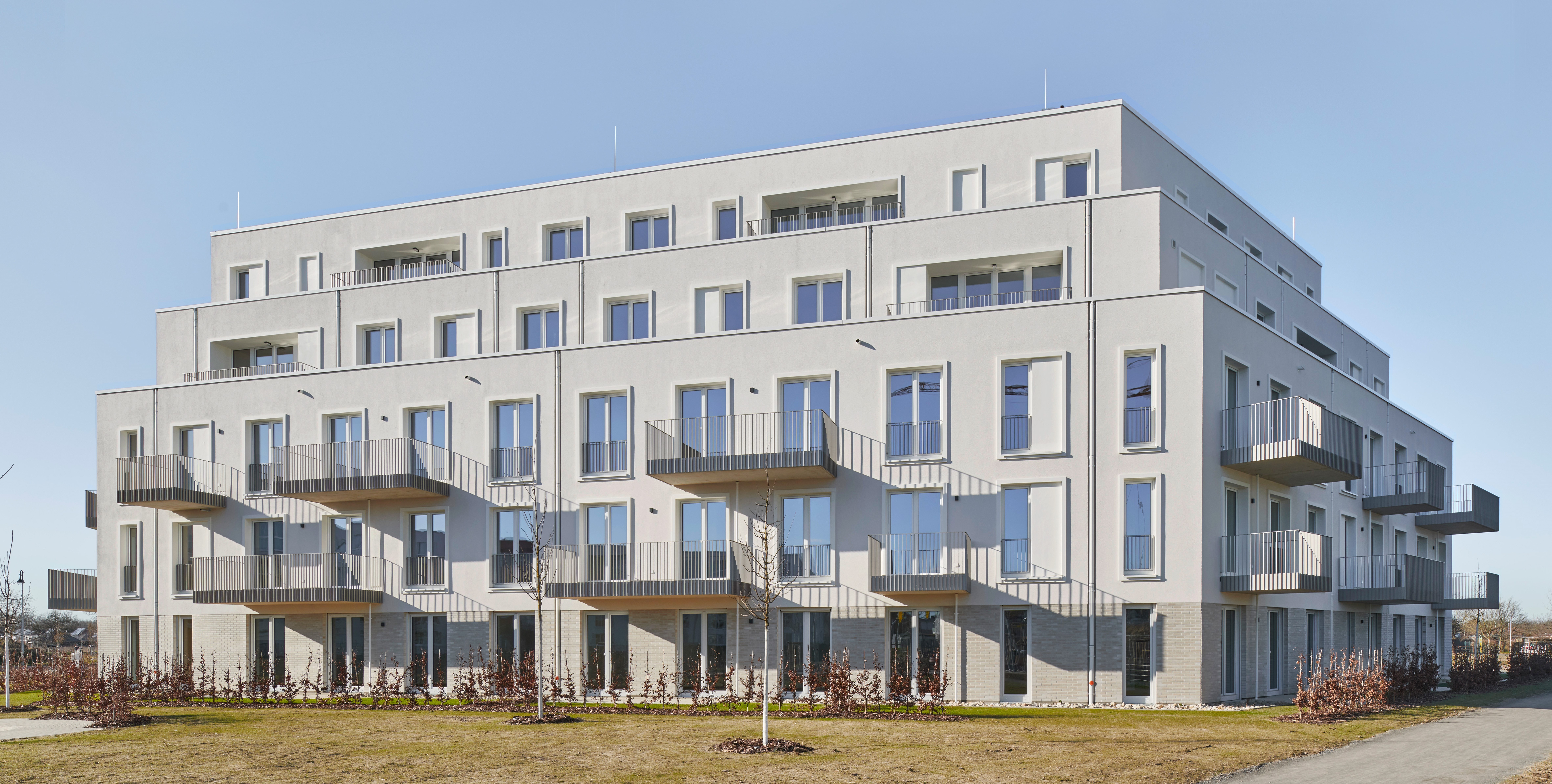 Blick auf einen Wohnkomplex am Wölper Ring, Weißes Gebäude, teilweise mit Balkonen versehen, Solitärbauweise