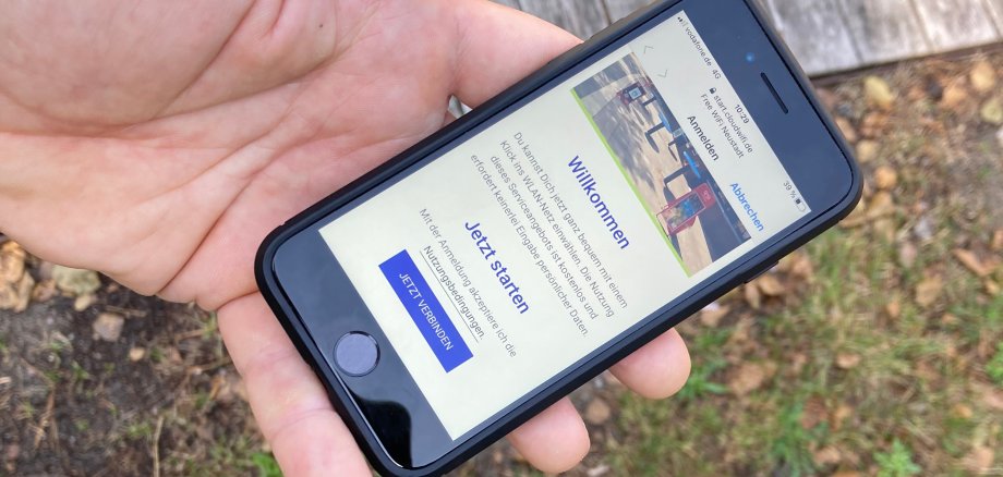 Pressefoto Handy zeigt Startseite WLAN Mardorf Nahaufnahme einer Hand, die ein Handy hält. Man kann den Bildschirm erkennen, auf dem die Startseite zum neuen WLAN-Hotspot zu sehen ist.