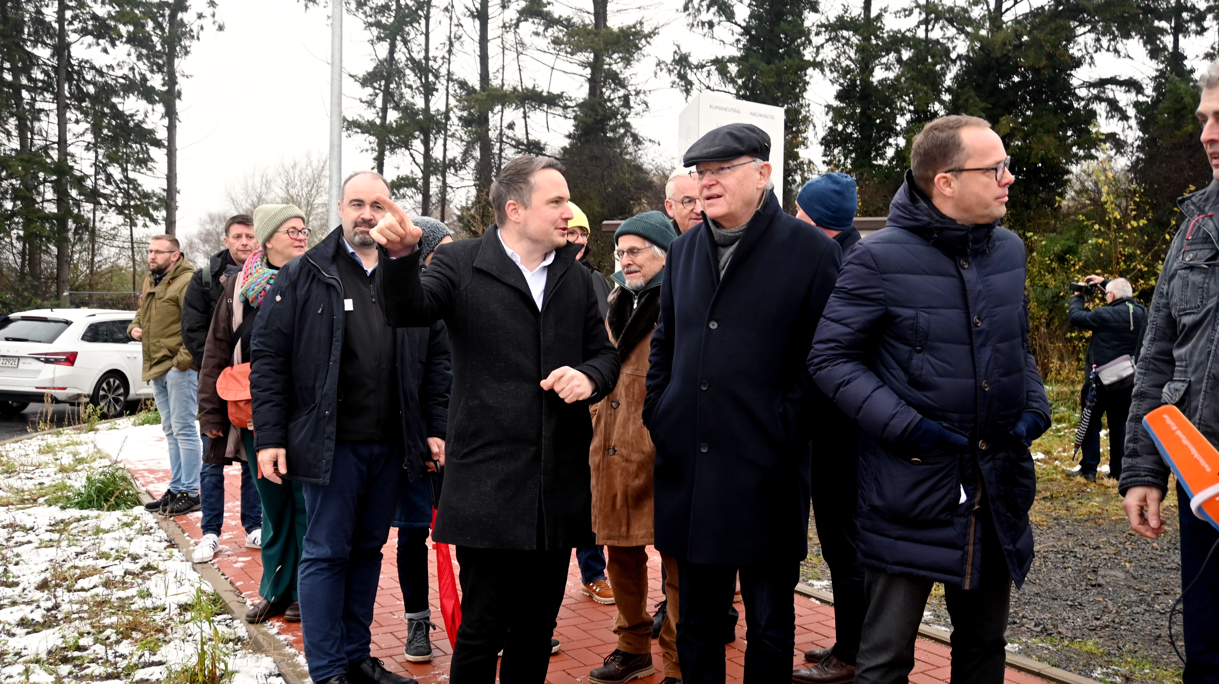 Eine Gruppe Menschen geht draußen einen Weg entlang. Vorneweg Neustadts Bürgermeister Herbst (links) und Niedersachsens Ministerpräsident Stephan Weil (rechts). Beide sind im Gespräch miteinander.