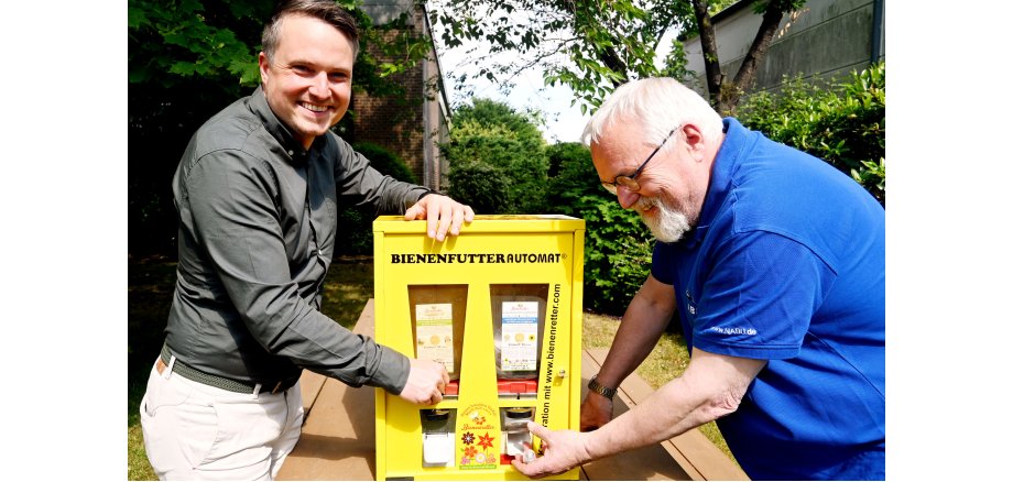 Bürgermeister Dominic Herbst und Reinhard Hoffknecht, 1. Vorsitzender des NABU Neustadt e.V., testen den neuen Bienenfutterautomaten.
