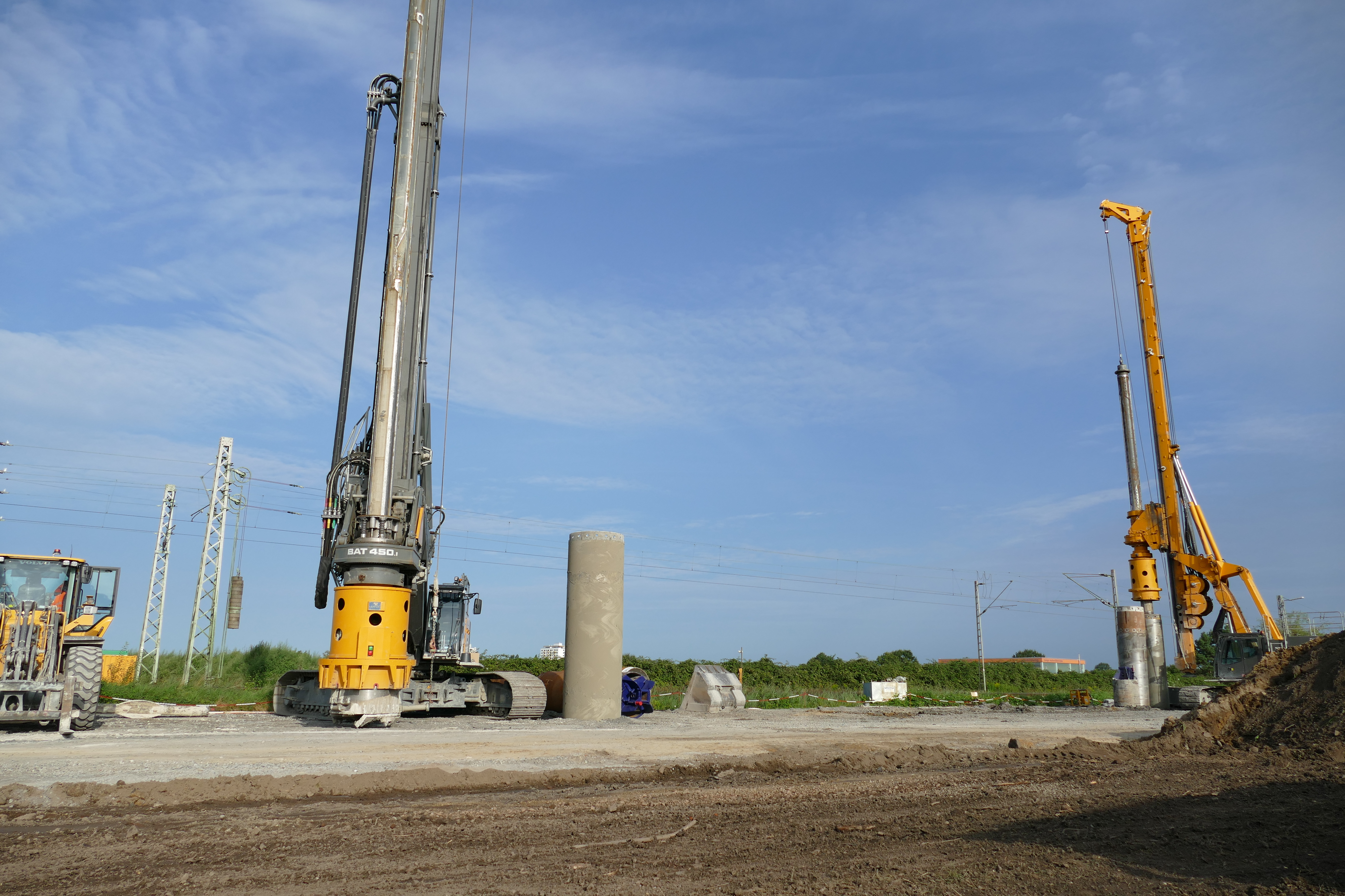 Blick auf die Baustelle für die Brücke über die Bahngleise in der Kernstad. zwei 20 Meter hohe Bohrmaschinen und ein Bagger sind zu sehen.