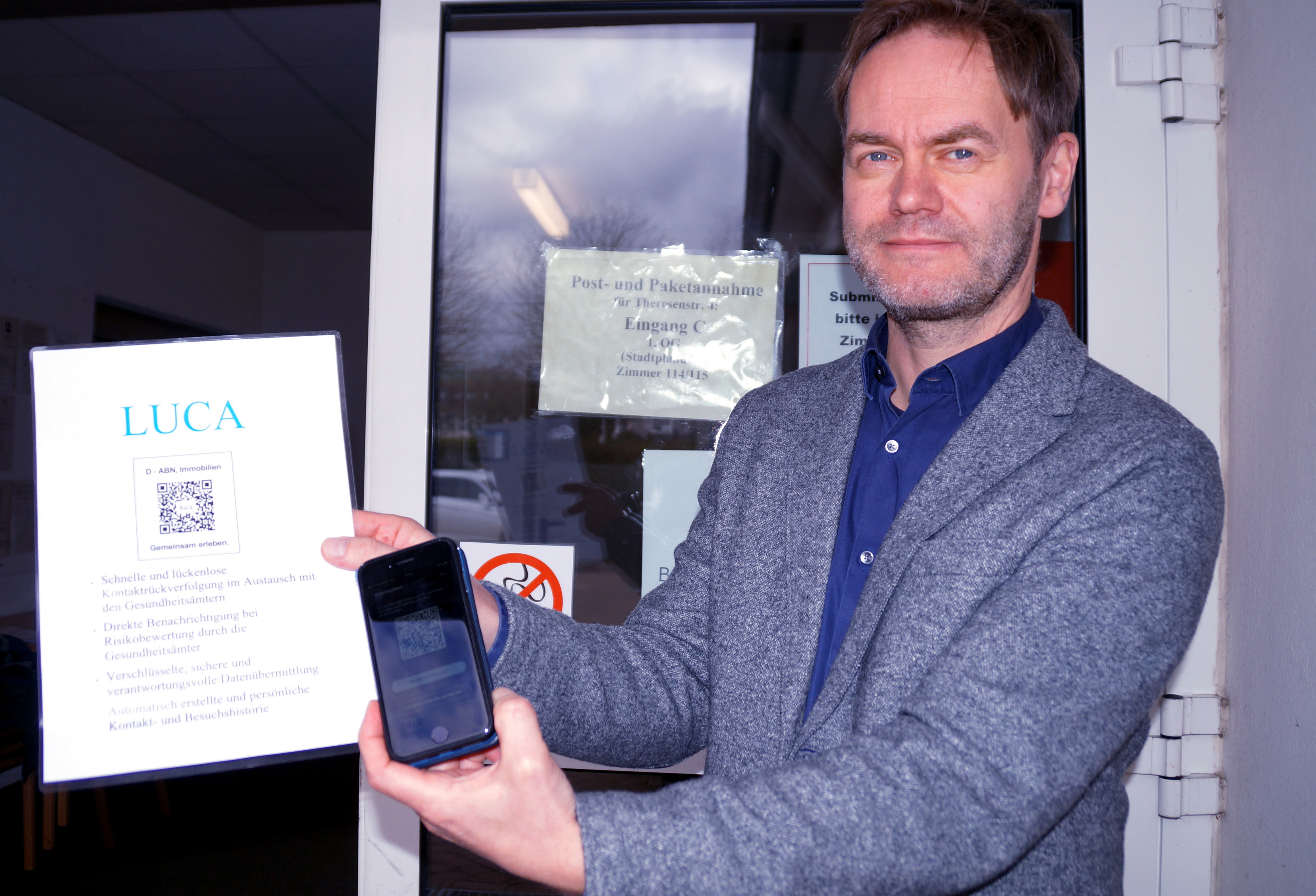 Fachbereichsleiter 3 Jörg Homeier hält in seiner Hand den QR-Code und ein Handy mit der luca App