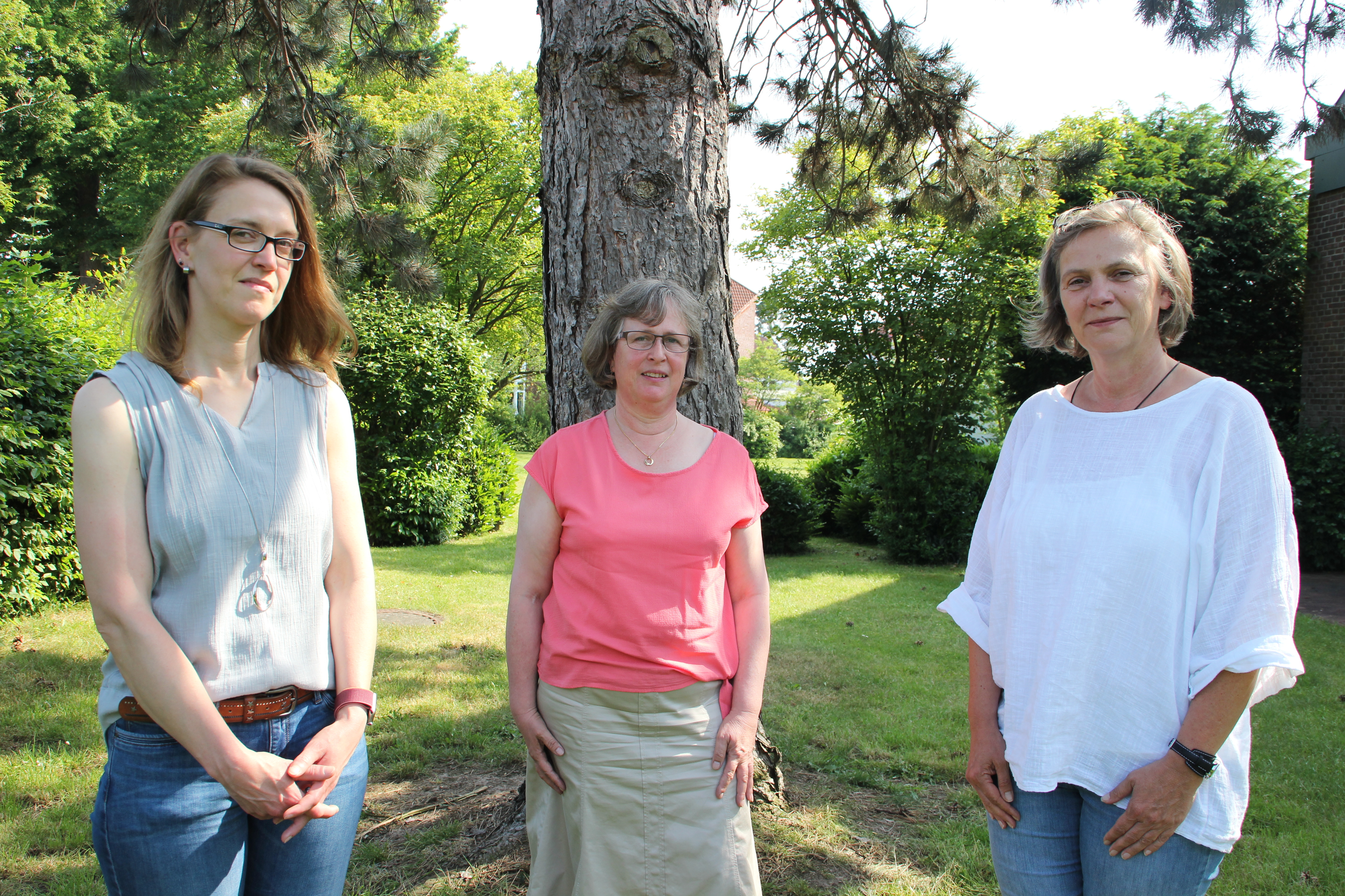 Auftakt Aktionsplan Inklsuion Drei Frauen stehen vor einem Baum auf einer Grünfläche und schauen in die Kamera.