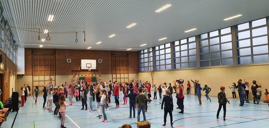 Viele Kinder spielen und tanzen in der neuen Sporthalle in Hagen. 