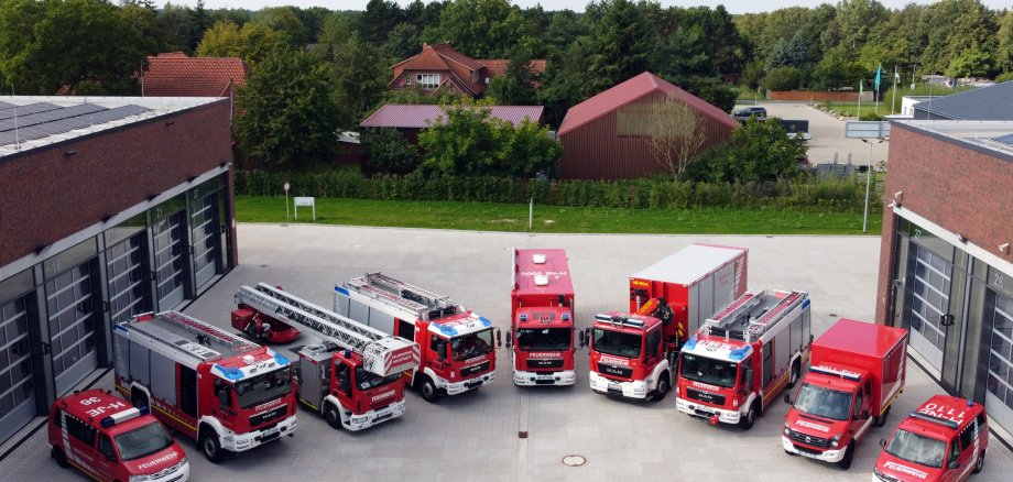 Luftaufnahme des Innenhofs Feuerwehrzentrum. Dort stehen im Halbkreis 9 Feuerwehrfahrzeuge.