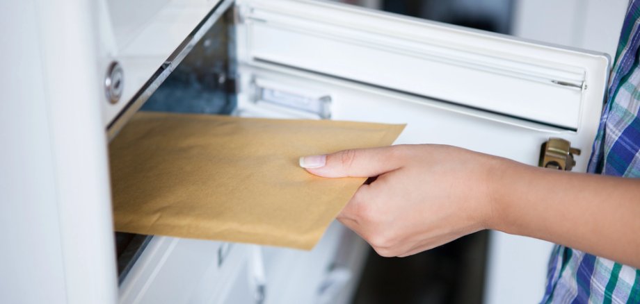 Woman's hand pulling envelop from mailbox