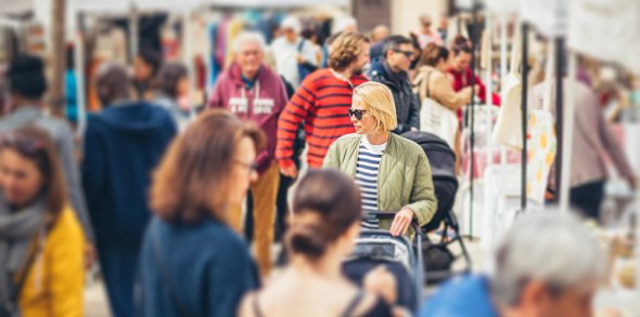 Symbolbild Flohmarkt Blick in eine Menschenmenge, die zwischen Flohmarktständen flaniert.