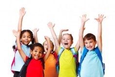 zu sehen sind fünf Kinder in bunten Shirts, die jubelnd die Arme heben