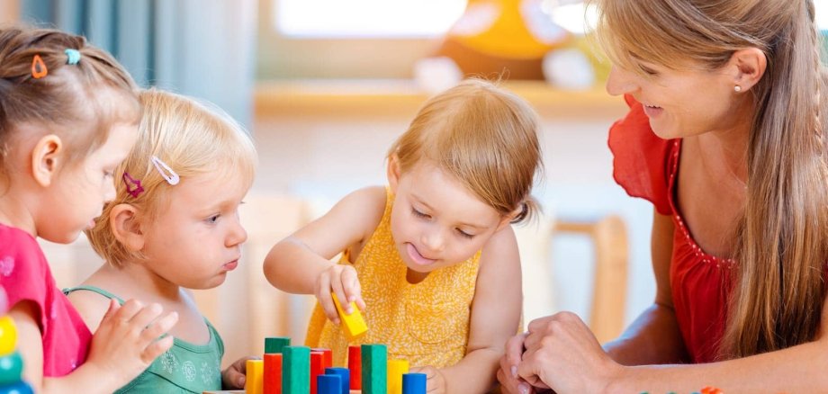 Kita spielende Kinder man sieht spielende Kinder und eine Betreuungskraft in einer Kindertagesstätte
