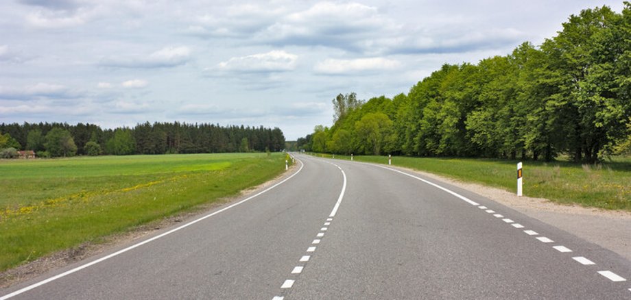 Symbolbild Landstraße Landstraße zwischen Wiese und Wald