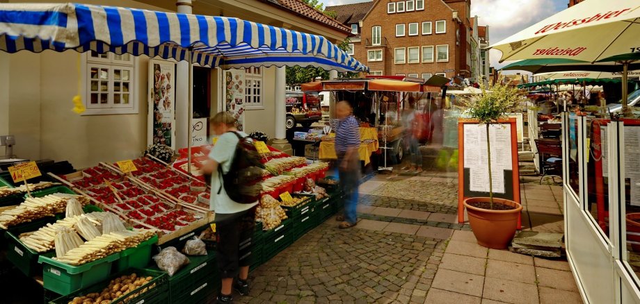 Blick auf den Wochenmarkt in Neustadt. Links ein Gemüsestand