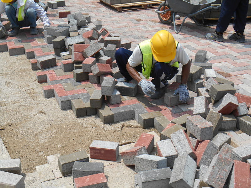 Ein Arbeiter pflastert eine Straße.