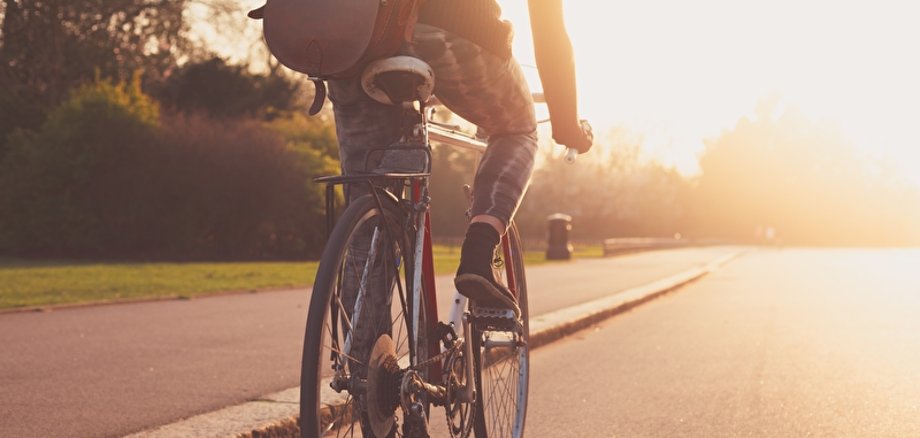 Fahrradfahrer im Sonnenlicht junge Frau radelt bei Sonnenuntergang im Park