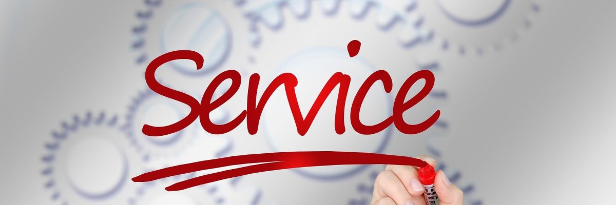 Symbolbild Service Eine Hand schreibt mit einem riten Schrift das Wort Service. Im Hintergrund sind Zahnräder zu sehen.