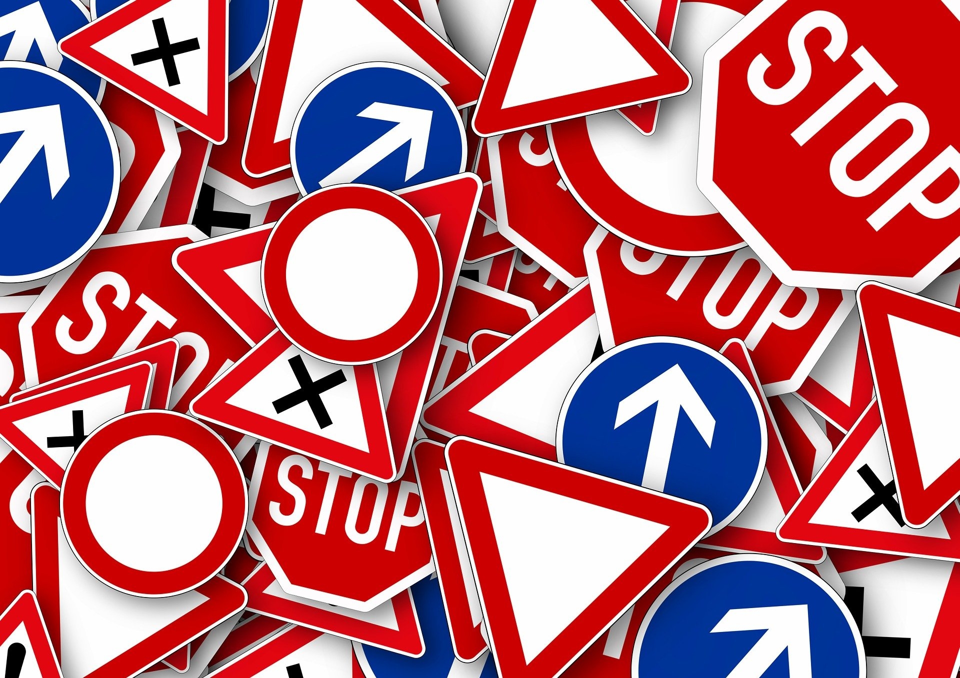 zu sehen sind viele verschiedene Straßenschilder, die übereinander liegen