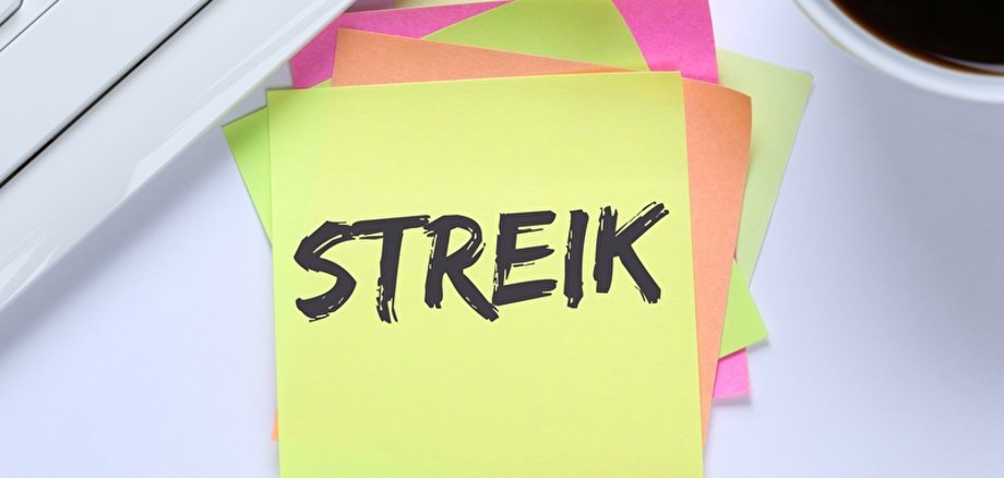 Ein Notizzettel mit dem Wort Streik liegt auf einem Schreibtisch.