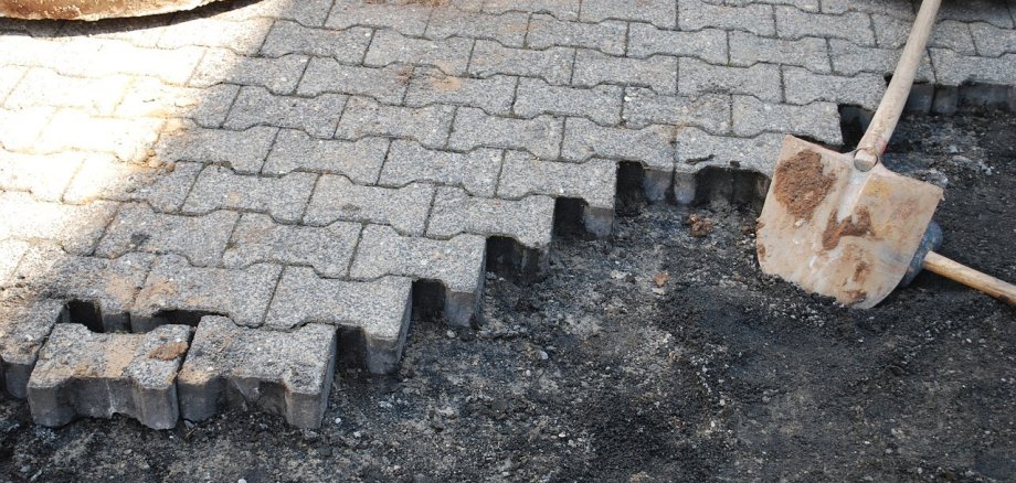 Steine eines Bodens, der verlegt wird und eine Schaufel