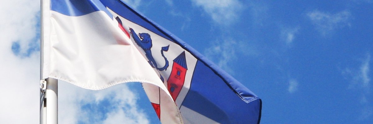 Neustadt Flagge Nahaufnahmke der Flagge mit dem Stadtwappen Hintergrund blau-weiß