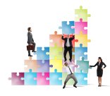 Treppe zum Erfolg mehrere Menschen versuchen auf verschiedenen Wegen eine Fläche aus Puzzleteilen zu erklimmen. Zwei machen eine Räuberleiter, einer geht die Treppe aus Puzzleteilen seitlch hinauf